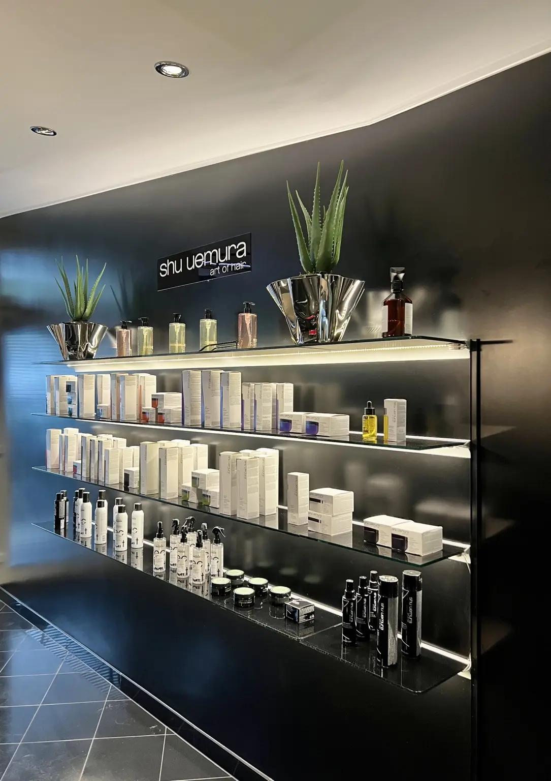 Beleuchtete Produktregale in einem Friseursalon
